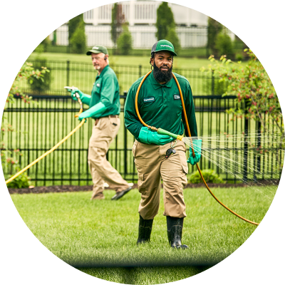 Two workers tending to lawn